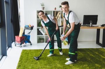 Happy,Young,Janitors,Claning,Carpet,And,Smiling,At,Camera,In